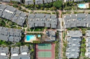 Aerial View Of Condo Community With Tennis Court And Pool In Sol