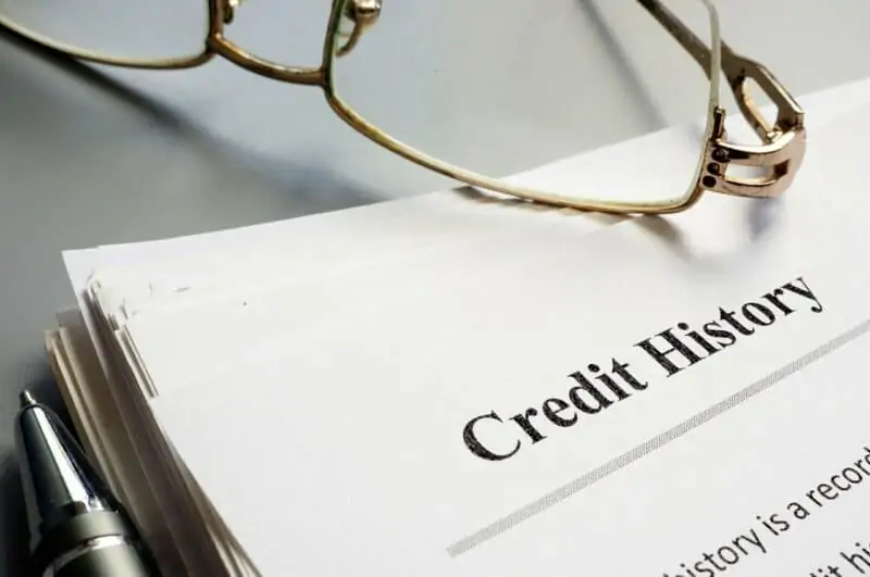 paper titled "credit history" with glasses laying on top