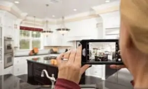 woman taking picture of kitchen on mobile phone