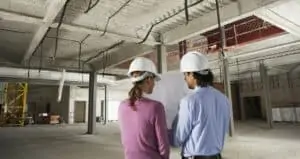 two people in hard hats surveying commercial property