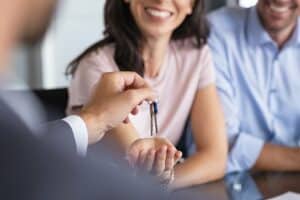 Close up of man hand giving house keys to woman