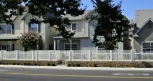 line of light color homes with white picket fence